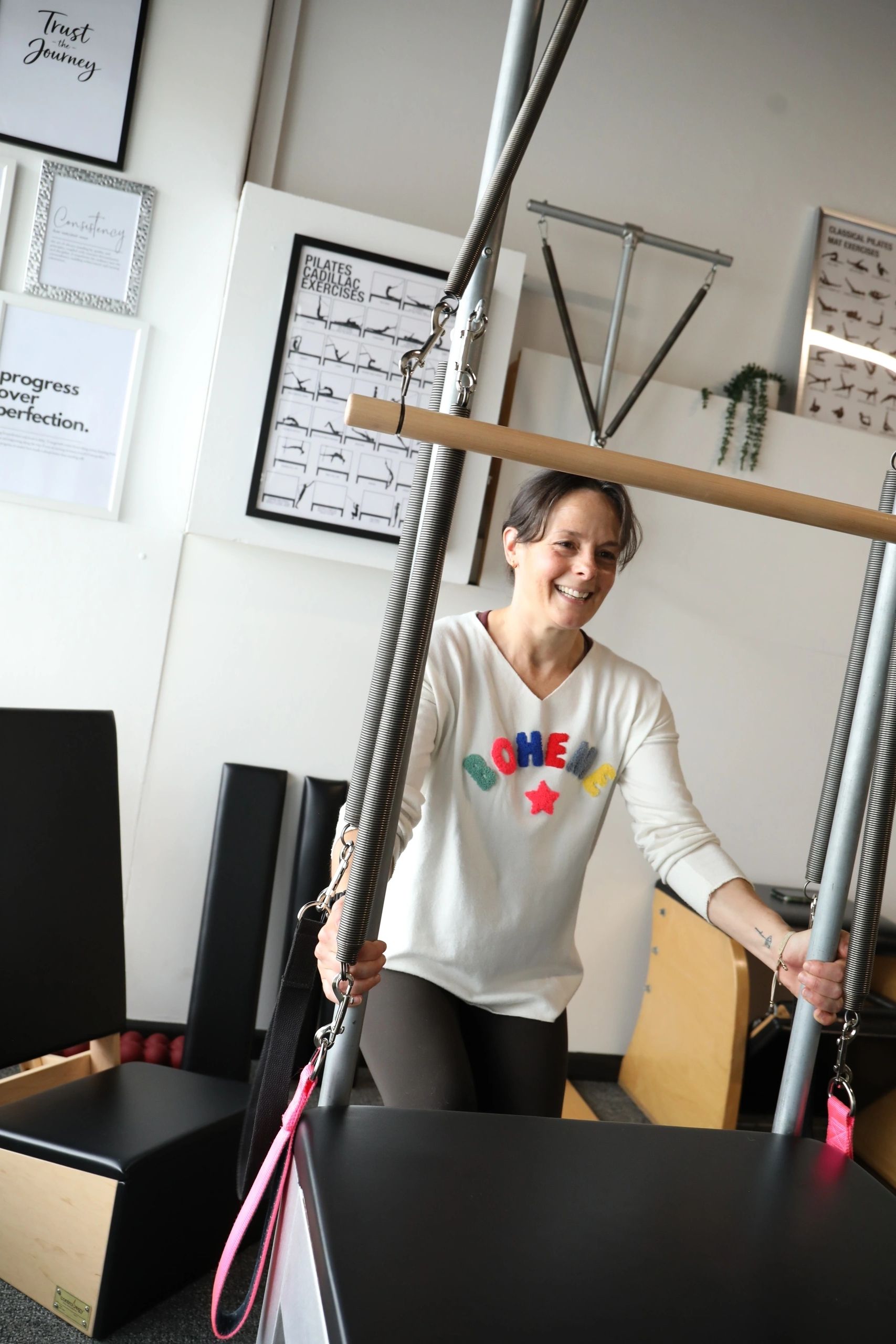 Woman smiling during exercise with Pilates equipment.